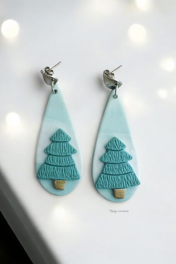 Minimalist Christmas Tree Earrings handmade from polymer clay, featuring teal trees on a marbled background with stainless steel hooks.