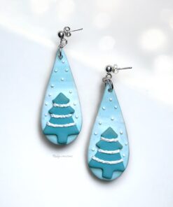 Snowy Christmas Tree Earrings handmade from polymer clay, featuring teal trees with white snow details on a soft blue background.